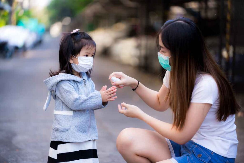 woman applying spray to asian kid